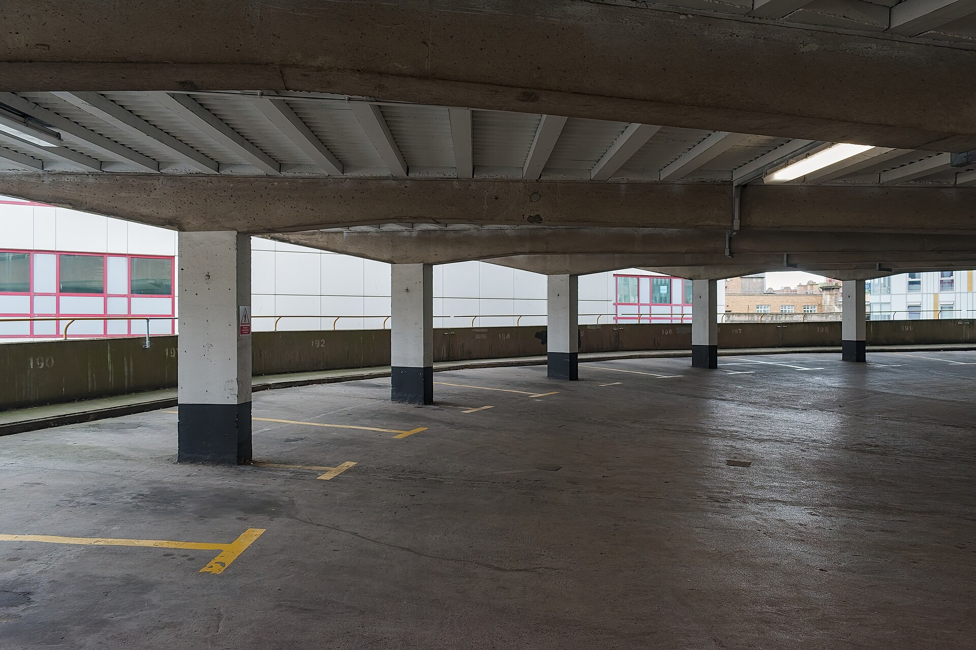 Parking con pilares pintados de blanco y negro y plazas señalizadas.